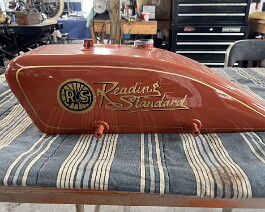 Restored gas tank with painted logo and pinstripe (left side).